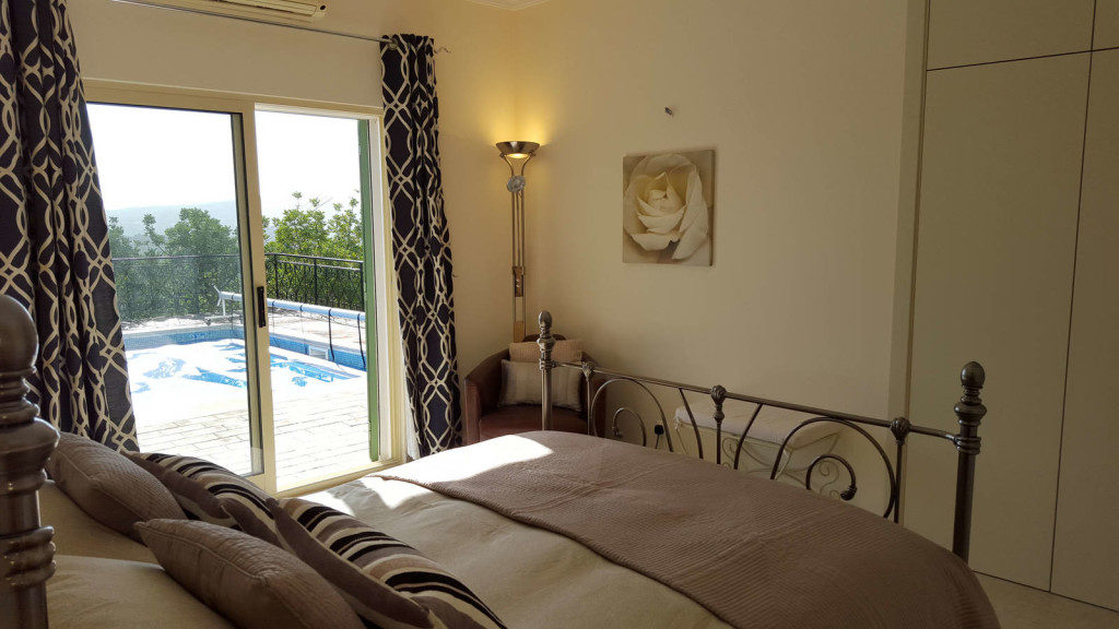 King size bedroom with ensuite overlooking the pool and views beyond.