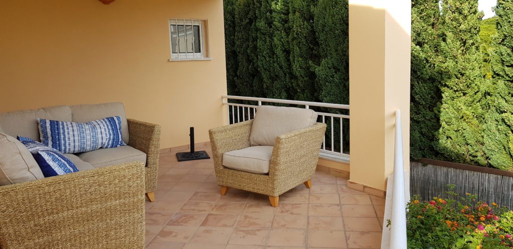 Third terrace with rattan furniture overlooking gardens